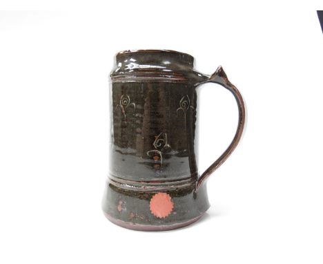 MICHAEL CARDEW (1901-1983) (ARR) An Abuja Pottery tankard, tenmoku and dark greenish glaze with white flower motifs. Impresse