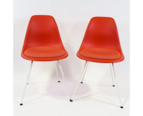 CHARLES EAMES for Vitra - a pair of red DSX chairs with upholstered cushion and white coated base, maker's labels and moulded