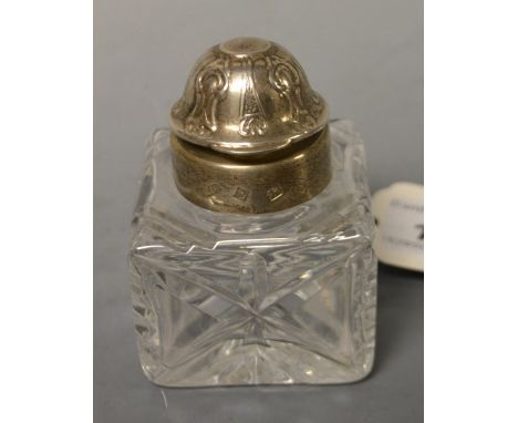 A cut glass inkwell with silver top