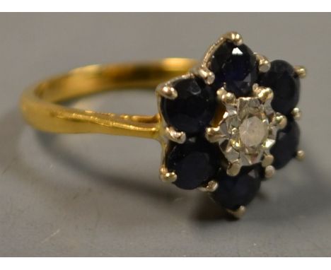 A diamond and sapphire flower head cluster ring, central round brilliant cut diamond, approx 0.16ct, surrounded by six round 