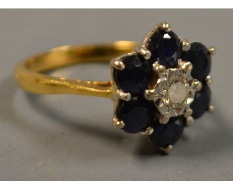 A diamond and sapphire flower head cluster ring, central round brilliant cut diamond, approx 0.16ct, surrounded by six round 