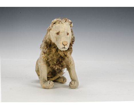 An unusual seated Steiff lion 1920s, with golden mohair, clear and black glass eyes with brown backs, pink and black stitched