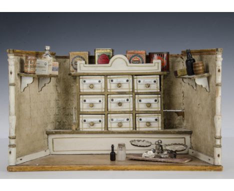 A German toy shop for the English market circa 1900, white painted, original Art Noveau wallpaper with nine drawers with cera