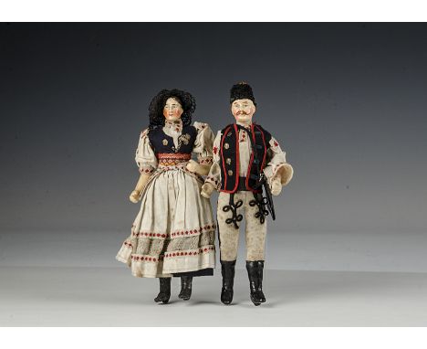 A pair of 19th century German composition dolls, each with blue painted eyes and one heavy brow above a lighter brow, the man