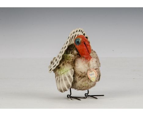A Steiff Tucky Turkey, circa 1956, with mohair body, velvet head, felt wings and tail, metal feet, script button and chest ta