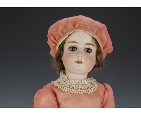 A William Goebel child doll, with brown lashed sleeping eyes, brown mohair wig, jointed composition body, pink dress, matchin