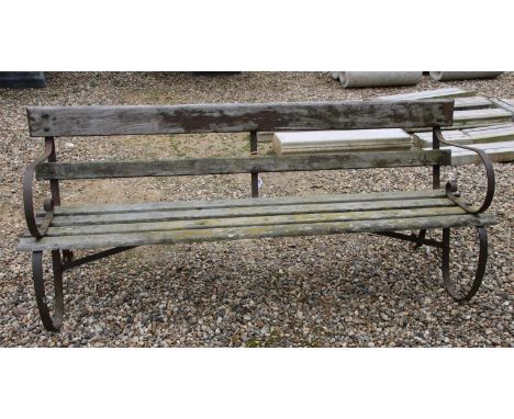 A wrought iron and slatted garden bench, 183 cm wide