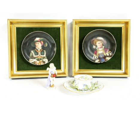 A Meissen figure of a putti, holding a mask and wearing a skull cap, and an inkwell with floral encrustations and two mounted