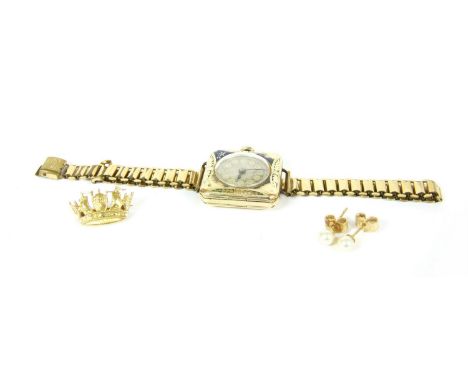 A gold naval crown brooch, marked 9ct, a ladies 9ct gold and enamel mechanical watch with later expanding bracelet, a cushion