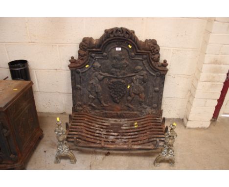 An antique cast iron grate with ornate brass front and fire back with vine decoration
