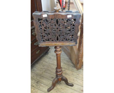 A Victorian mahogany double sided music stand with carved fretwork on tripod base