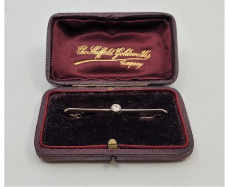 An Edwardian 15ct. gold and diamond bar brooch, bezel set single old-cut diamond, length 5.3cm. (gross weight 3.1g), in jewel
