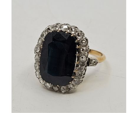 A large precious yellow metal, sapphire and diamond ring, claw set mixed cushion shape cut sapphire to raised centre (approx,