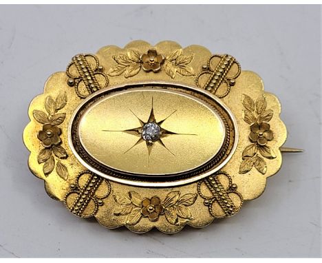 A Victorian 15ct. gold mourning brooch, of lobed oval form, illusion set single old-cut diamond to centre, with glazed oval p