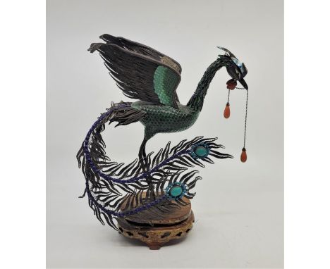 A Chinese silver and enamel figure of a standing peacock, polychrome enamelled and raised upon oval wooden stand (stand at fa