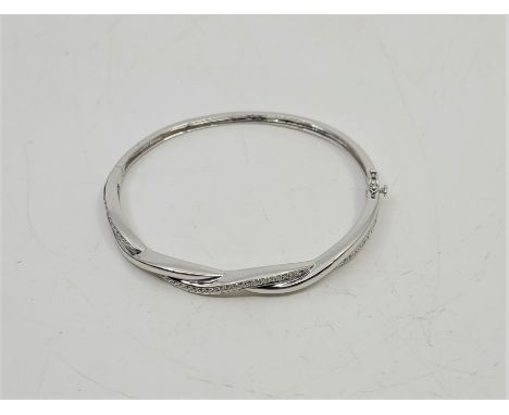 An 18ct. white gold and diamond set hinged bangle, the front fashioned as entwined bands, one set approx. forty-four round br