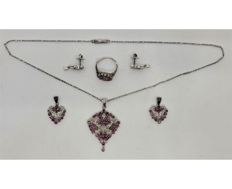 A white metal, ruby and diamond pendant, ring and&nbsp;drop earrings en suite, the pierced pendant mount set numerous round m