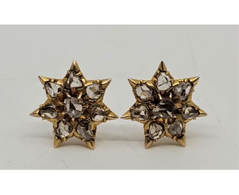 A pair of precious yellow metal diamond cluster earrings, each having star form mount set eight rose-cut diamonds (yellow met