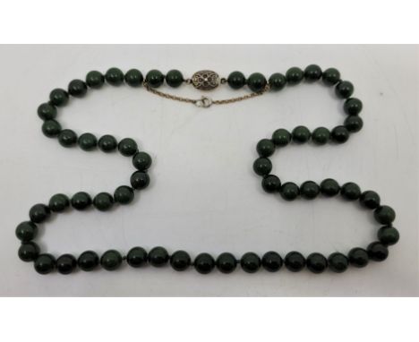 A Chinese spinach green jade necklace, with silver clasp and yellow metal security chain, length 69cm, bead diameter 10mm.&nb