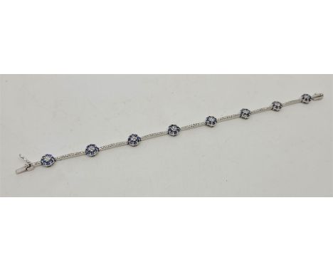 An 18ct. white gold, diamond and sapphire bracelet, formed from circular links each set four round brilliant cut diamonds to 