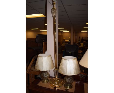 A brass standard lamp; and a pair of brass table lamps with shades.