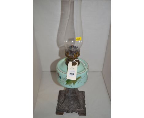 A Victorian oil lamp on decorative metal base.