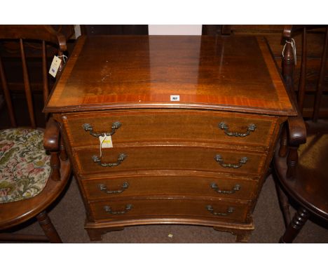 A reproduction inlaid mahogany reverse bowfront small chest of four graduating drawers with canted reeded corners, raised on 