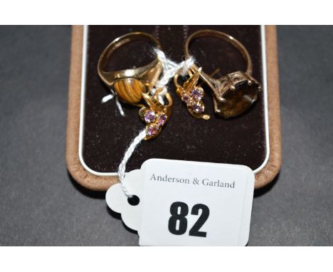 A pair of amethyst set floral pattern stud earrings; a tigers eye set ring on 9ct. gold shank; and a quartz ring.