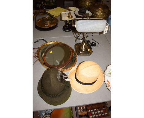 A reproduction desk lamp with oxidized metal base and opaque glass shade; together with three hats; and two oval mirrors.