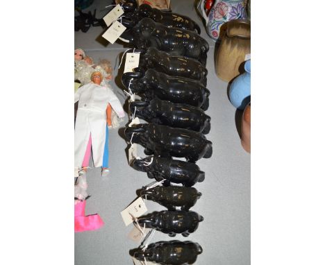 Ten black graduated ceramic African elephants.