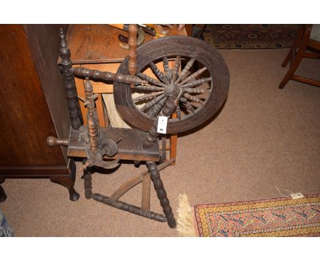 A stained wood spinning wheel with turned bobbin design.