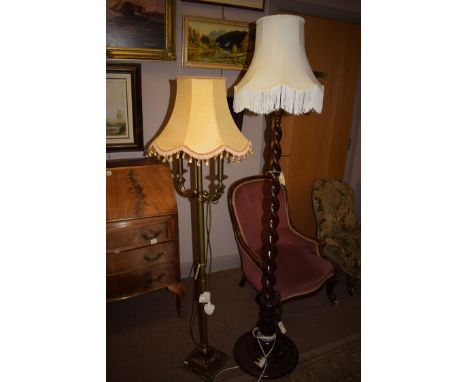 A spiral twist standard lamp with cream coloured shade; and a brass standard lamp with pale yellow shade.