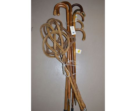 Two wicker carpet beaters; and eight wooden walking sticks.