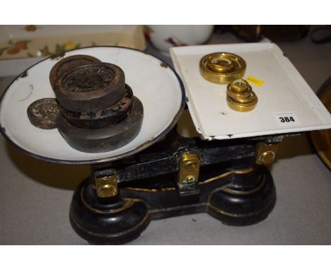 A cast iron kitchen balance with enamel plates; and a selection of brass and cast iron weights; together with a cast iron ski