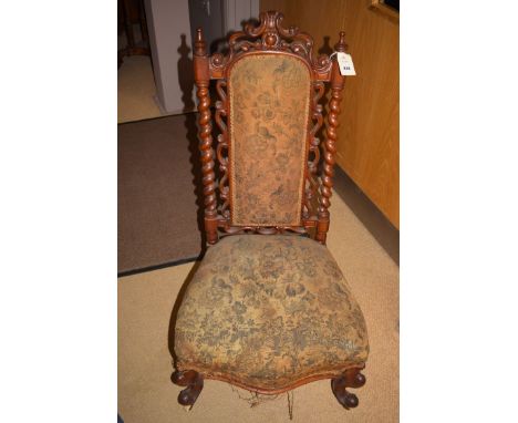 A Victorian low seat nursing chair, the high back with padded central panel flanked by decorative carvings and spiral support