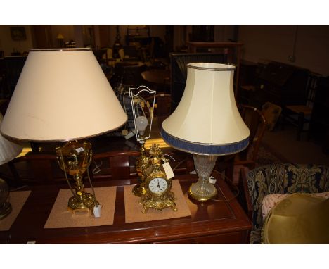 A decorative brass mantel clock; together with two brass table lamps; and brass vase-shaped table lamp.