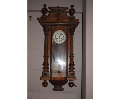 A 19th Century mahogany cased Vienna style wall clock, with arched glazed panelled door, decorative turned and reeded pilaste