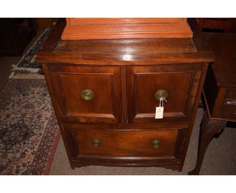 A Continental style stained wood chest of one long and two short deep drawers with brass ring-pull handles.