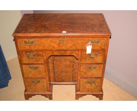 A George I style fine quality burr walnut kneehole writing desk, fitted a combination of one long and five short drawers, wit