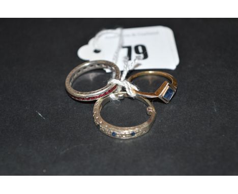 A ruby eternity ring set in white metal, ring size K; together with a sapphire ring, ring size G; and a sapphire and diamond 