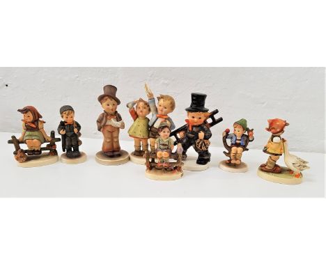 EIGHT GOEBEL HUMMEL FIGURESincluding a boy and a girl sitting on fences, a boy in top hat singing and holding sheet music, a 