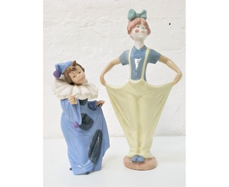 TWO NAO FIGURINES comprising a young girl dressed like a clown with baggy trousers and a painted face, 29cm high; and a young