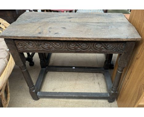 A 19th century oak side table with a rectangular planked top above a carved frieze on ring turned legs
