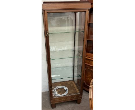 A shop display cabinet with a caddy top above a glass back, sides and door with a parquet floor on square legs, 180cm high x 