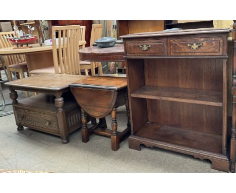 A reproduction oak bookcase with a rectangular crossbanded top, two drawers and a shelf on bracket feet, 69cm wide together w