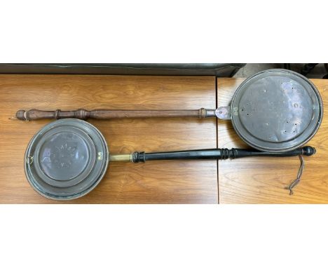 A copper bedwarming pan together with another copper bedwarming pan 