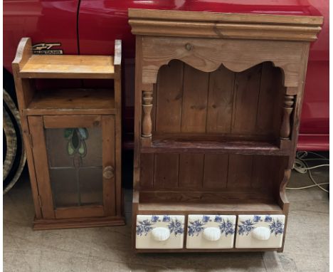 A pine wall unit with a moulded cornice and shelf with three pottery drawers together with another wall cabinet 