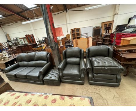 A green leather four piece suite comprising a three seater settee, two arm chairs and a footstool