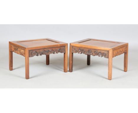 A pair of Chinese hardwood low tables, 20th century, each rectangular panelled top above a scroll frieze on block legs, lengt