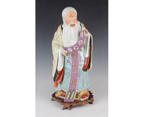 A Chinese famille rose porcelain figure of Shoulao, 20th century, modelled standing wearing a colourful robe and holding a sc